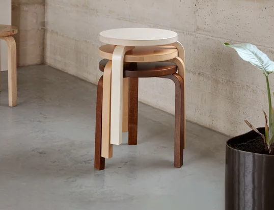 Le tabouret 60 d'Artek dans la vue d'ambiance : Le tabouret à trois pieds peut être empilé et placé n'importe où dans la pièce grâce à son aspect simple.