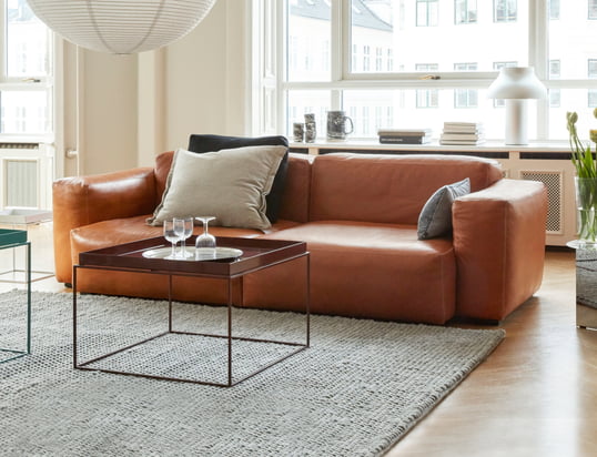Le canapé Mags Soft de Hay dans la vue d'ambiance : Le canapé en cuir de haute qualité de couleur cognac peut être parfaitement combiné avec des coussins beiges et un tapis gris.