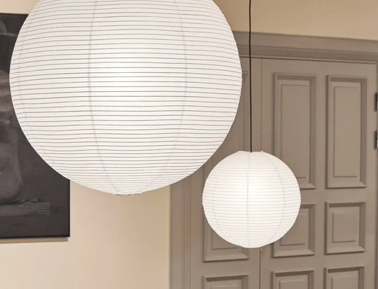 L'abat-jour Rice Paper du fabricant danois HAY , fabriqué en papier de riz, présente une délicate structure rainurée qui s'étend longitudinalement autour de l'abat-jour en forme de globe.