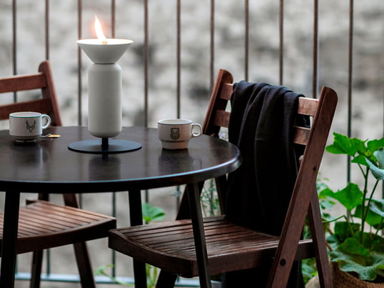 La lampe à pétrole Poppy de Northern dans la vue d'ambiance : l'ouverture en forme d'entonnoir de la lampe rappelle une fleur ouverte et met ainsi des accents élégants sur le balcon ou la terrasse.