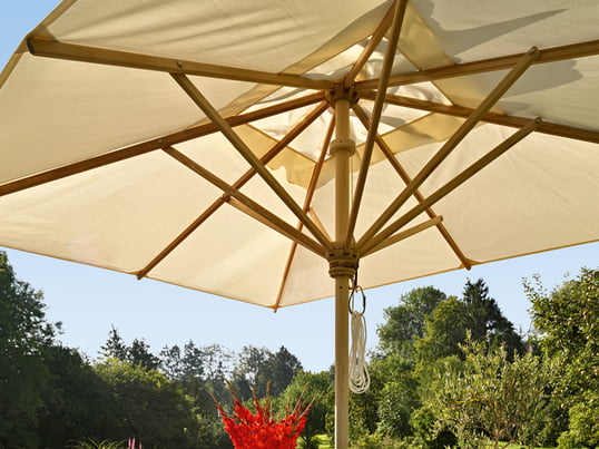 Le parasol haut de gamme de Skagerak est disponible en plusieurs tailles, formes et matériaux. Sous les voiles blanches du parasol, on trouve une protection contre le soleil pendant les chaudes journées d'été.