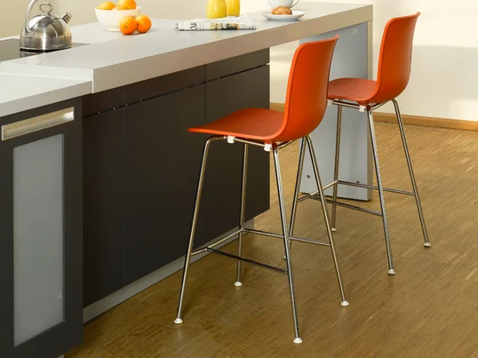 Le tabouret de bar fait partie de la collection Hal, conçue par Jasper Morrison pour Vitra. Les chaises de cette collection ont en commun la forme de la coque d'assise. Le tabouret est disponible en blanc et en orange.