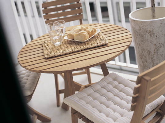 Les meubles de jardin en bois donnent un aspect rustique au balcon. Sur la table Vendia avec des chaises de Skagerak vous prendrez un merveilleux petit déjeuner en plein air.