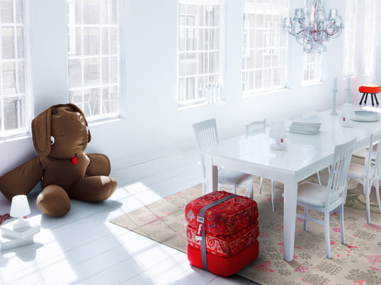 Les meubles du fabricant néerlandais Fatboy s'intègrent parfaitement dans l'intérieur minimaliste de cette salle à manger lumineuse. Les tissus rouges offrent un accroche-regard qui ne passe pas inaperçu.