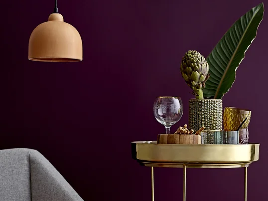 Le vase à picots de Bloomingville en vue d'ambiance sur une table d'appoint à côté du canapé. Des feuilles isolées et un artichaut font merveille dans le vase.