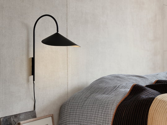 Arum Applique murale en noir de ferm Living dans la vue d'ambiance. Parfait comme petite veilleuse à côté du lit ou lumière d'ambiance dans le couloir ou le salon.
