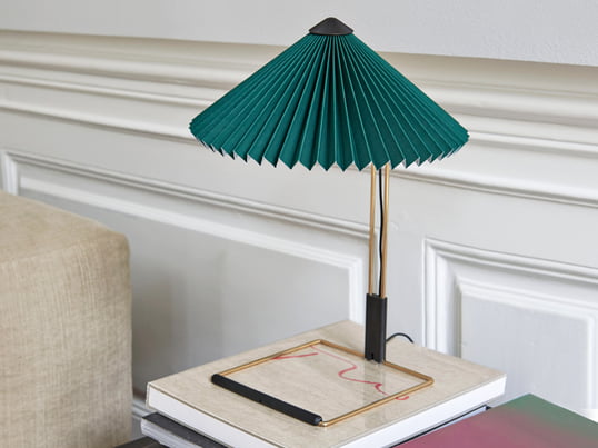 La lampe de table Matin LED de Hay dans la vue d'ambiance : La lampe de table avec son abat-jour plissé est particulièrement belle comme lampe de lecture à côté du lit.