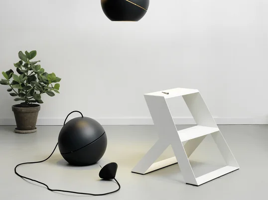 Le marchepied Split Step de Frederik Roijé en blanc dans la vue d'ambiance. L'escabeau est idéal pour monter des suspensions au plafond.