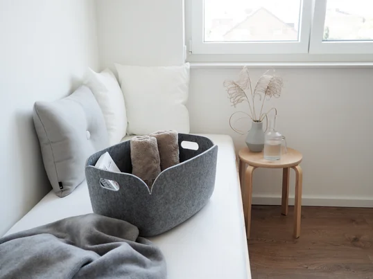 Le panier de rangement Restore de Muuto dans la vue d'ambiance : dans le panier en feutre, vous pouvez fournir des serviettes et d'autres petites choses à vos invités dans la chambre d'amis.