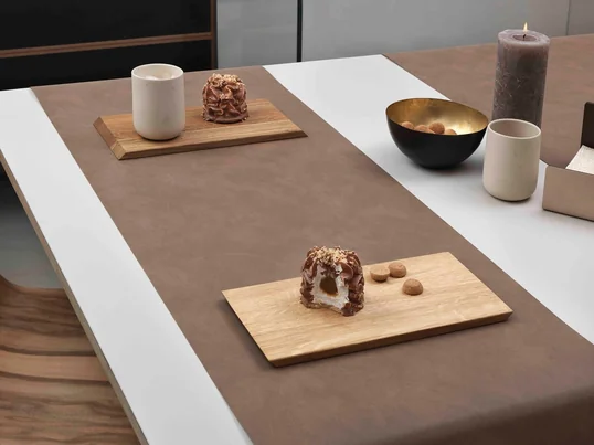 Le chemin de table de Lind DNA en nupo brun épouse parfaitement la table et ne bouge pas grâce au cuir souple
