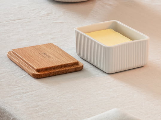 Le beurrier chic Legio Nova d'Eva Trio en chêne se compose d'un couvercle en bois de chêne et d'un bol en porcelaine fine avec un motif rainuré. Le morceau de beurre peut être conservé dans le bol en porcelaine et fermé par le couvercle en bois.