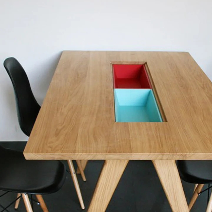 La table à manger Remix Collection de la famille Hansen avec des compartiments colorés au milieu.
