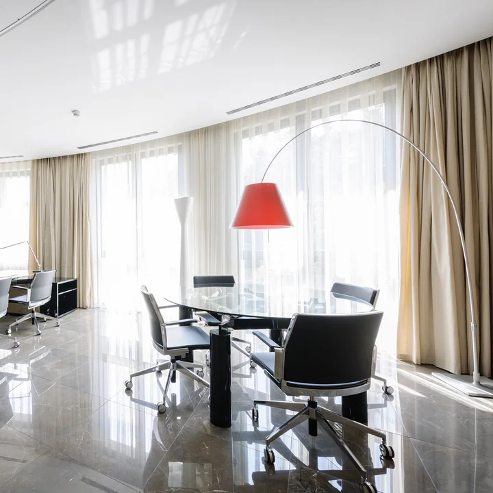 Le lampadaire Lady Costanza de Luceplan au-dessus d'une table ovale dans un bureau