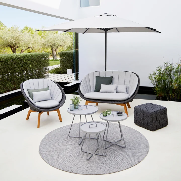 Peacock Fauteuil Lounge (5458) en teck / gris foncé avec tabouret Cube (8340) de Cane-line
