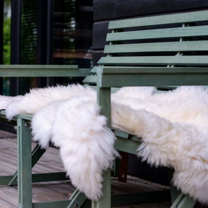 Peau de mouton de Weltevree sur un banc de jardin vert 