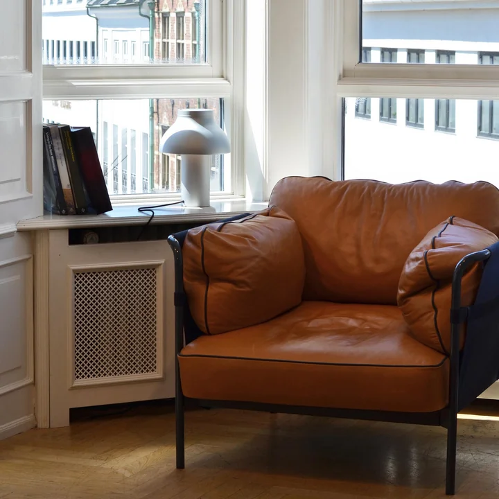 Lampe de table PC sur le rebord de la fenêtre à côté du fauteuil Can par HAY