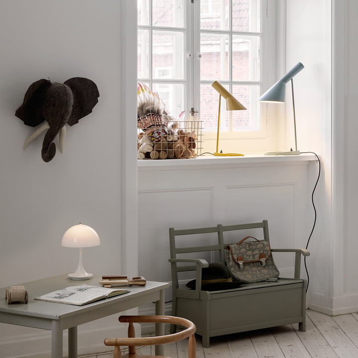 La lampe de table AJ de Louis Poulsen sur un rebord de fenêtre dans la chambre d'enfant