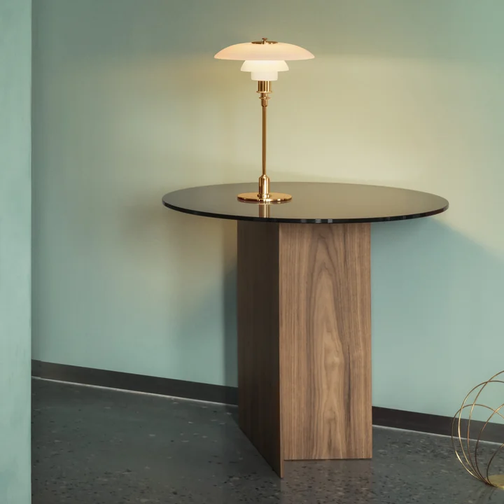 La lampe de table PH, laiton de Louis Poulsen sur une table d'appoint dans le couloir