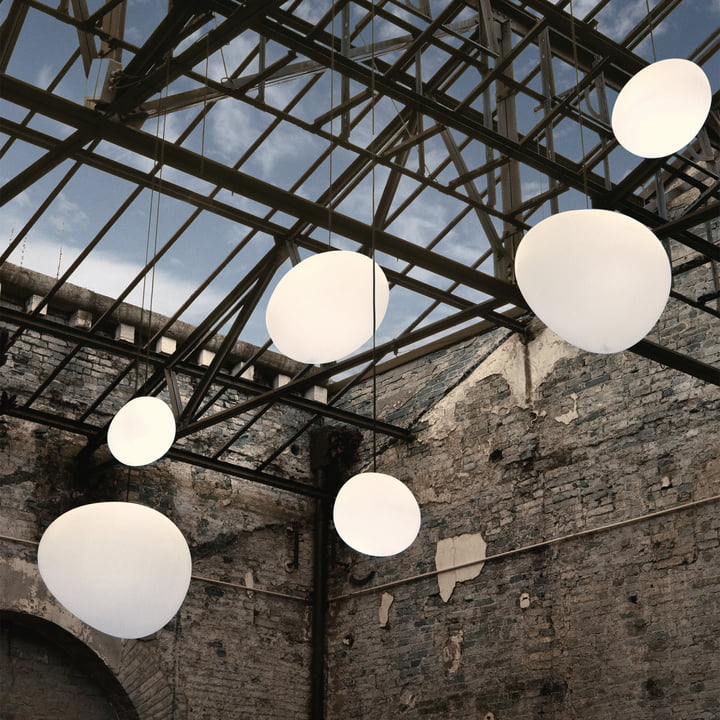 Les suspensions d' Outdoor Gregg, blanches de Foscarini dans un hall industriel