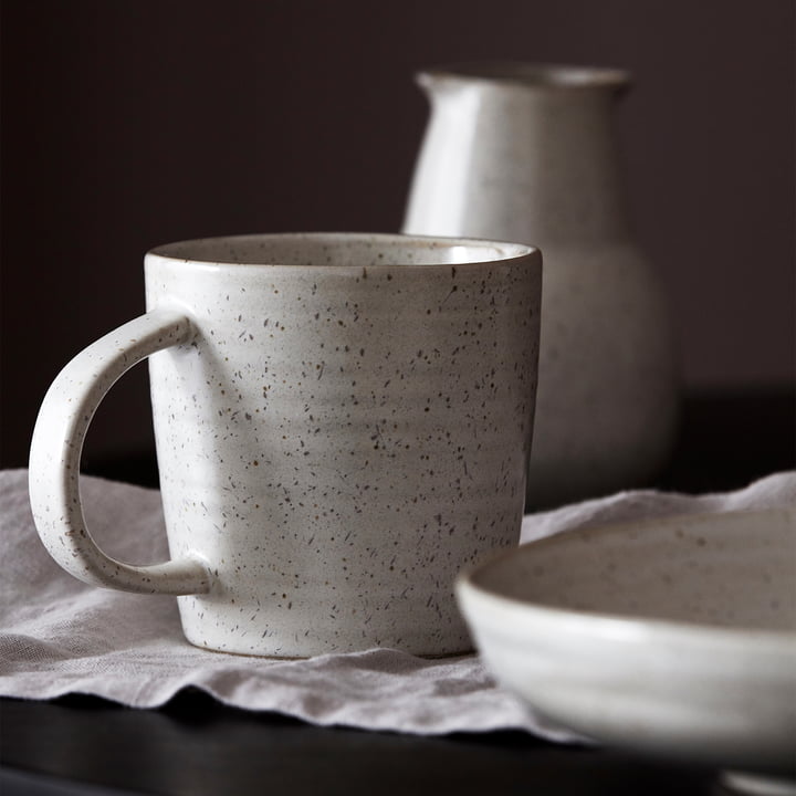 Le mug avec anse Pion, gris / blanc sur la table à manger