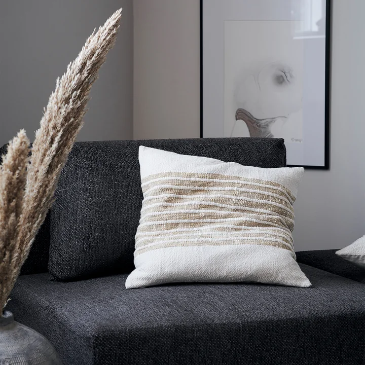 La taie d'oreiller Yarn, marron clair de House Doctor sur un fauteuil dans le salon