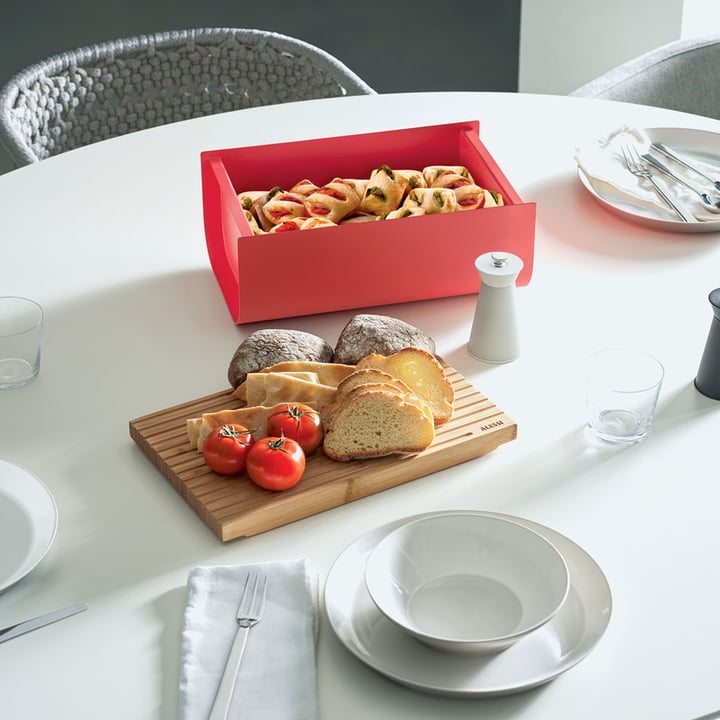 La boîte à pain Mattina avec une planche à découper en Alessi guise de boîte à biscuits sur la table à manger