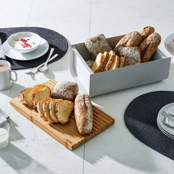 La boîte à pain Mattina avec planche à découper d'Alessi sur la table du petit-déjeuner.