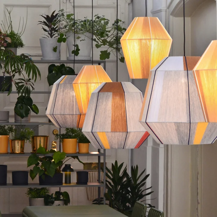 Les abat-jour Bonbon de HAY en état d'éclairage dans une pièce avec beaucoup de plantes