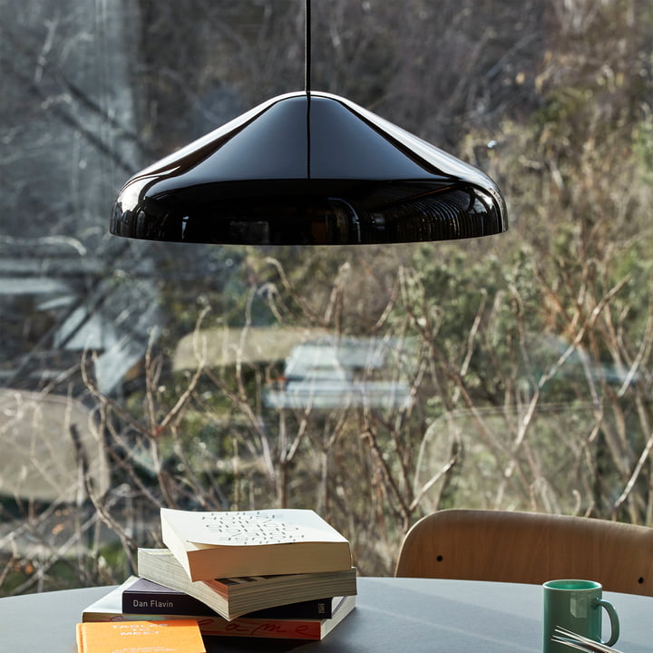 La suspension Pao Steel, Ø 47 x H 16,25 cm, noire par Hay sur une table ronde devant la fenêtre