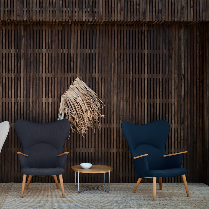 Le site CH78 Mama Bear Lounge Chair de Carl Hansen à côté d'une petite table d'appoint