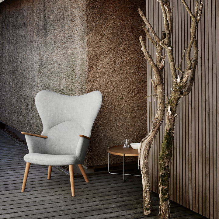 Le CH78 Mama Bear Lounge Chair de Carl Hansen à l'extérieur sur une terrasse en bois