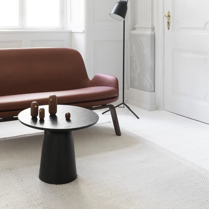 La table basse Turn de Normann Copenhagen devant un canapé en cuir dans un salon lumineux