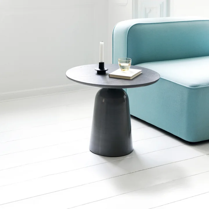 La table basse Turn de Normann Copenhagen à côté d'un canapé turquoise