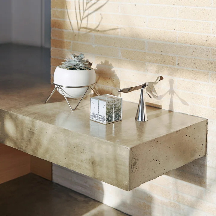 L'ouvre-bouteille Tipsy de Umbra parmi d'autres objets décoratifs sur le sol en pierre