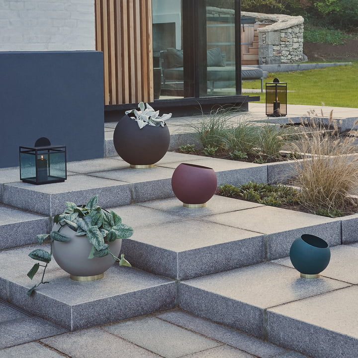 Le pot de fleurs Globe AYTM dans ses différentes versions sur un escalier en pierre à ciel ouvert