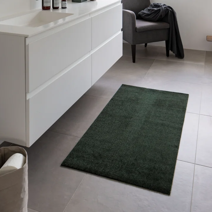 Le paillasson Unicolor de tica Copenhagen dans la salle de bain devant le meuble du lavabo