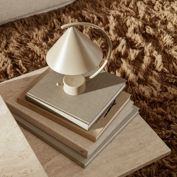 La lampe de table Meridian de Ferm Living en cashmere sur une table basse en travertin