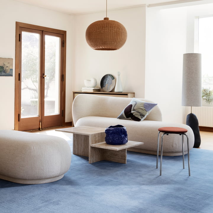 Le chaiselounge Rico de Ferm Living dans un salon lumineux en combinaison avec un ottoman et une table basse en pierre
