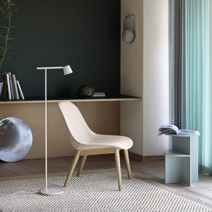 Le lampadaire Tip de Muuto à côté d'une chaise lumineuse dans l'espace de vie confortable