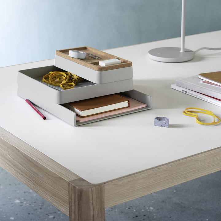 Le Arrange Desktop Organizer de Muuto sur un bureau blanc à côté d'un luminaire