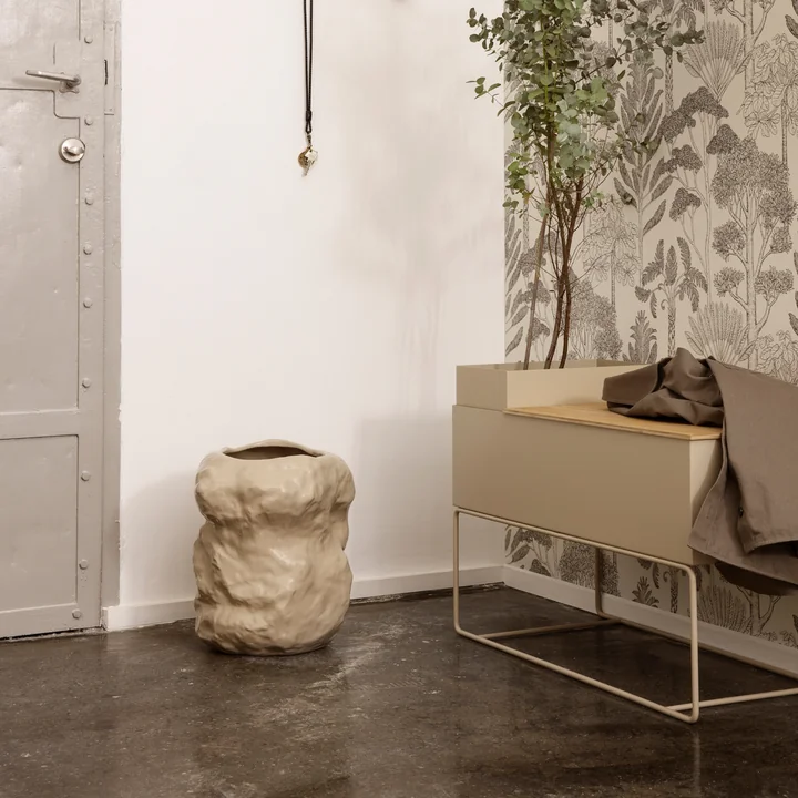 Le vase Tuck de Ferm Living in cashmere à côté d'une jardinière dans le couloir