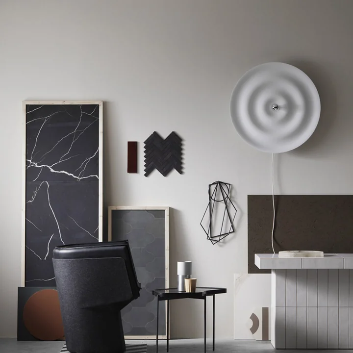 Le site Alma Applique et plafonnier de Wästberg dans une pièce pleine d'objets d'art géométriques en noir et gris