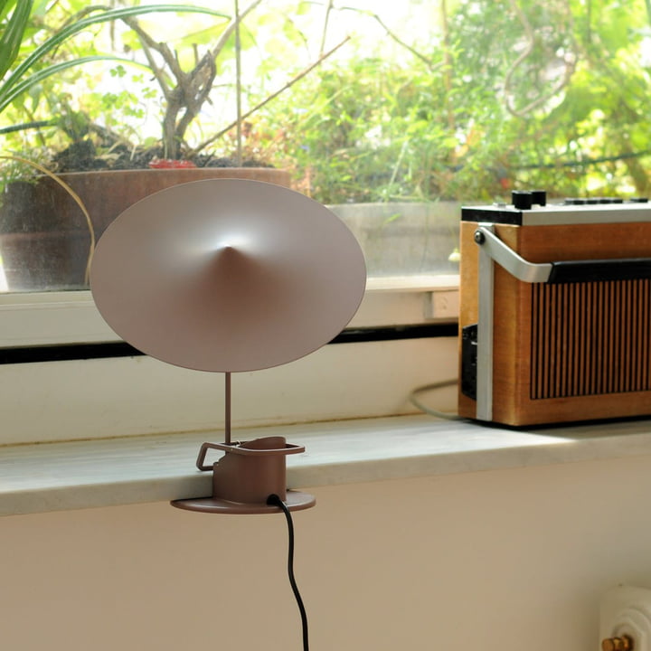 La lampe de table w153 île de Wästberg fixée sur un rebord de fenêtre à côté d'une radio