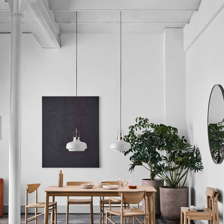 Le miroir Amore autour de & tradition dans une salle à manger lumineuse avec de hauts plafonds et une table à manger en bois clair