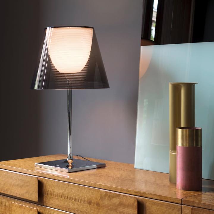 Le K Tribe Lampe de table T2 de Flos avec abat-jour transparent à la fumée sur une commode en bois