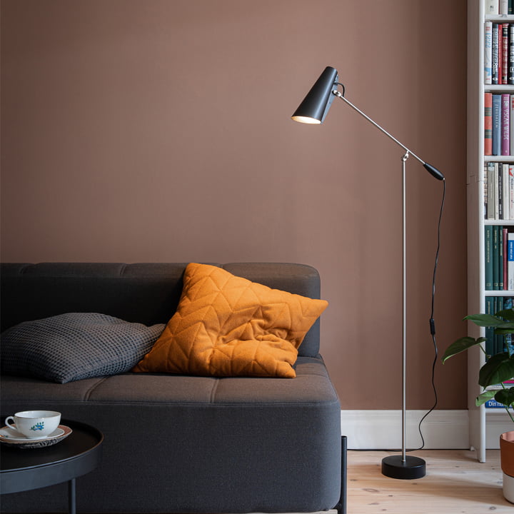 Le noir Birdy Lampadaire de Northern dans le salon à côté d'un canapé sombre