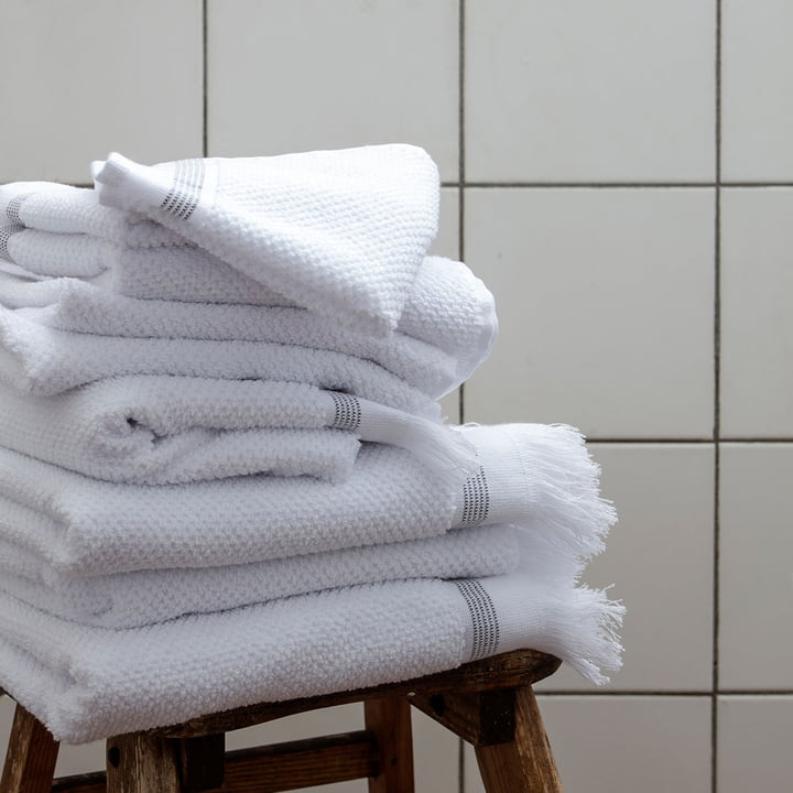 Les serviettes rayées de Meraki sur un tabouret dans la salle de bain