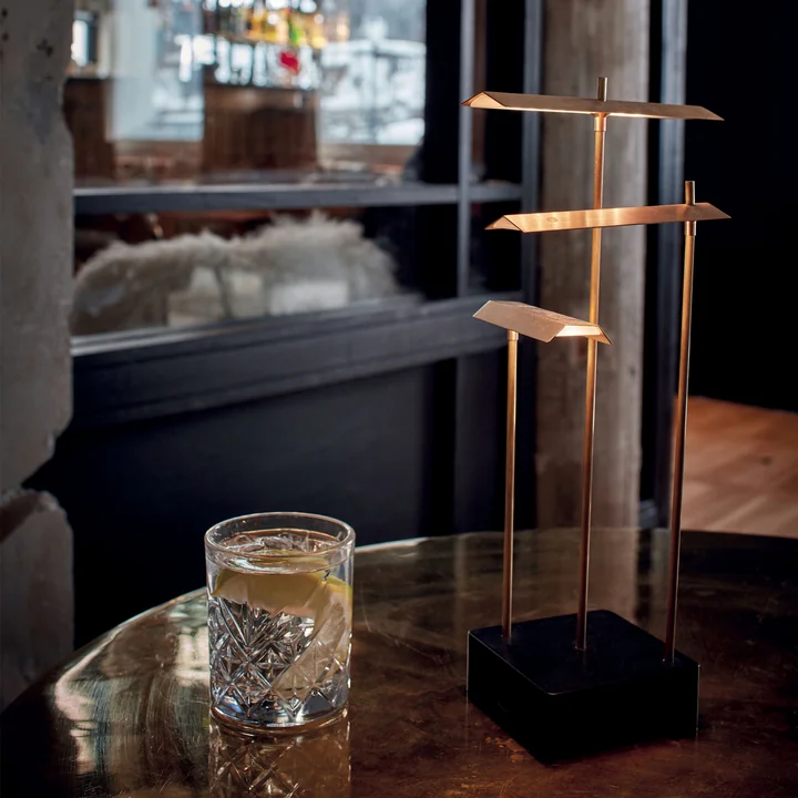 La lampe de table Knokke Akku LED de DCW sur une table dans un restaurant
