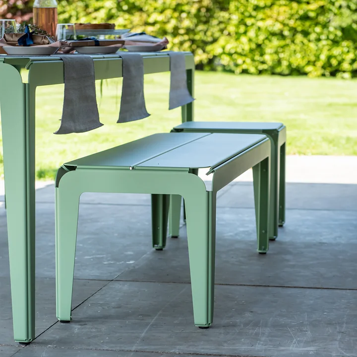 Le banc Bended Bench avec la table pliée sur des dalles de pierre