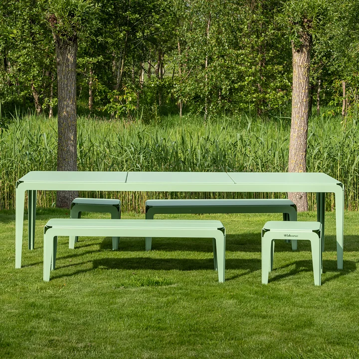 Le banc Bended Bench et la table Bended de Weltevree sur une pelouse verte